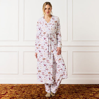 Woman wearing a long-sleeve robe with espresso martini pattern in a room with white paneled walls.