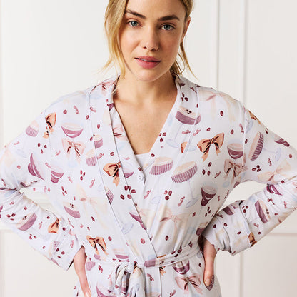 Woman wearing a espresso martini patterned robe with a white background