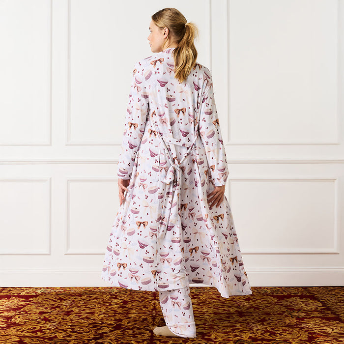 back image of woman wearing an espresso martini pajama set in a room with white paneled walls.