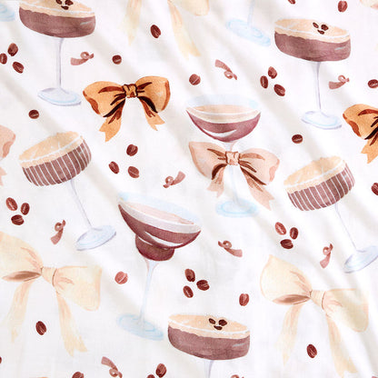 Pattern of espresso martini cocktail, bows, and coffee beans on a white background
