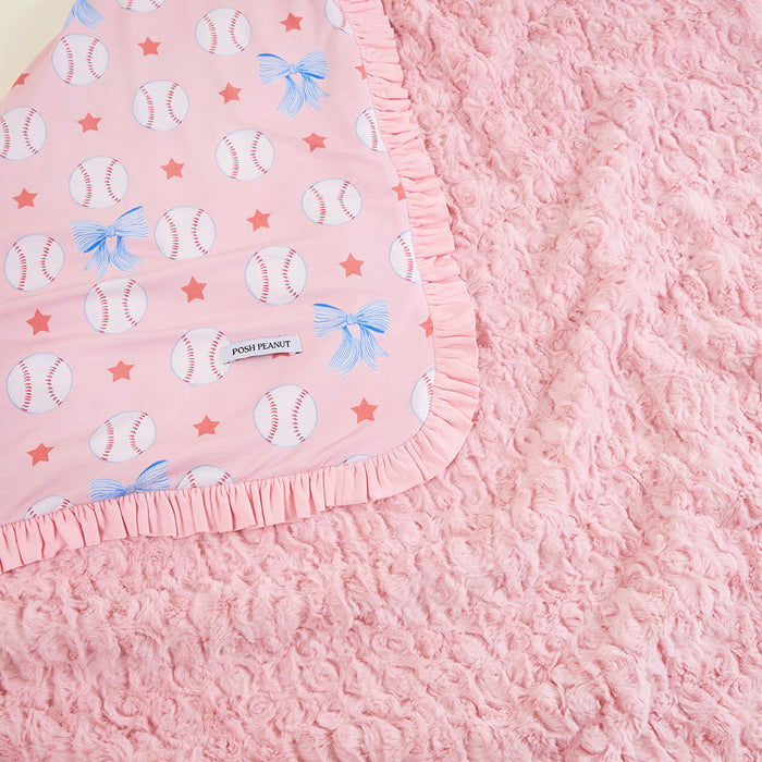 Pink blanket with baseball and bow pattern with a reversible plush side