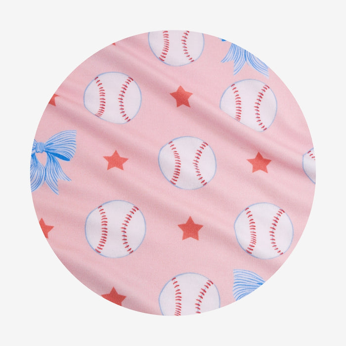 Circle swatch of pink fabric with baseballs, stars, and blue bows