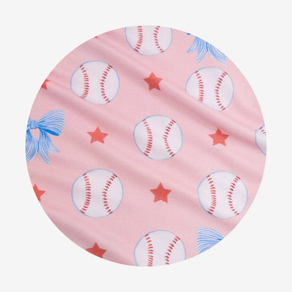Circle swatch of pink fabric with baseballs, stars, and blue bows