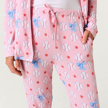 Pink pajama set with baseball and bow pattern on a plain background