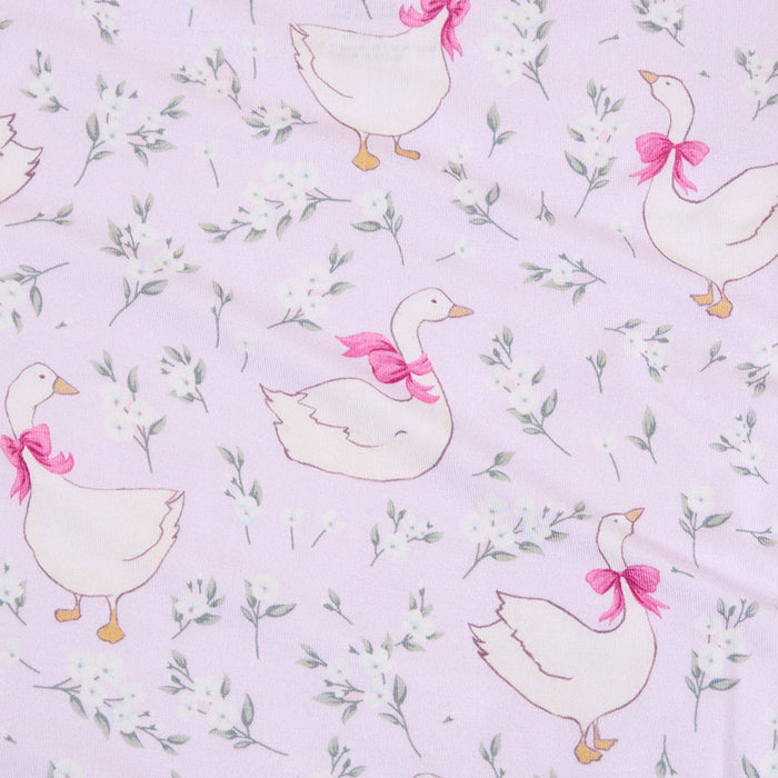 Pattern of white geese with pink bows on a light purple background