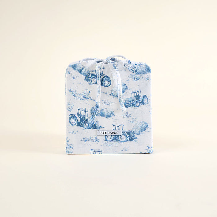 Baby blanket with blue tractor pattern on a light background