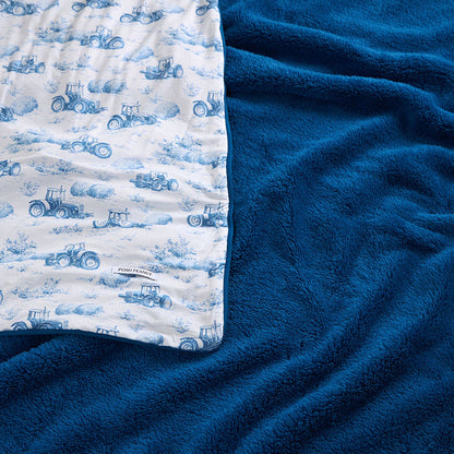 Blue blanket with tractor pattern on a white background
