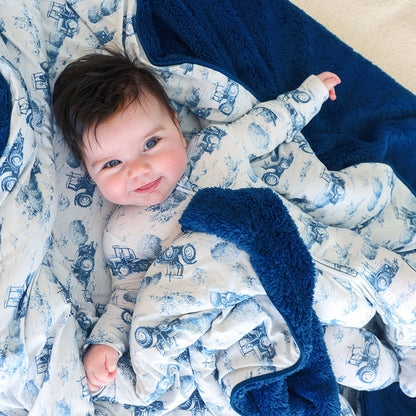 Baby lying on a blue and white patterned blanket