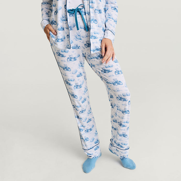 Person wearing blue and white pajama set with tractor pattern on a light gray background