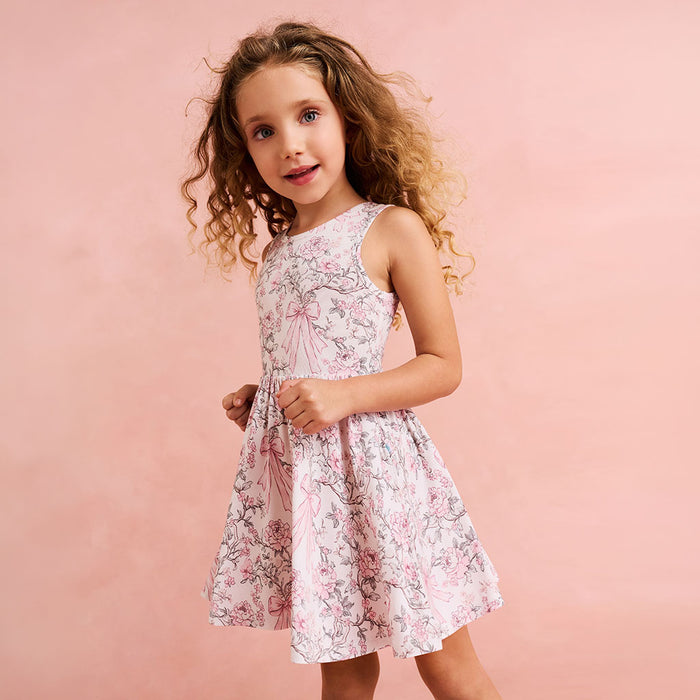 close up of child wearing a floral and bow printed dress