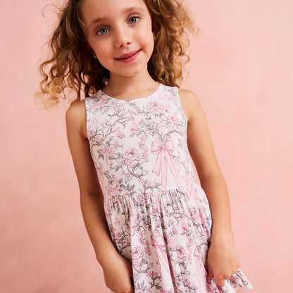 Young girl wearing a floral dress with a pink background