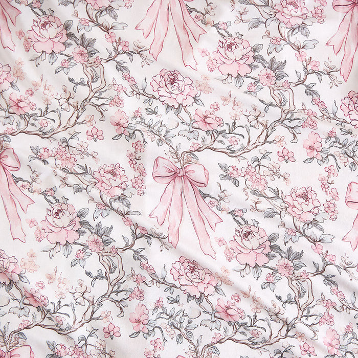 close up of child wearing a floral and bow printed fabric