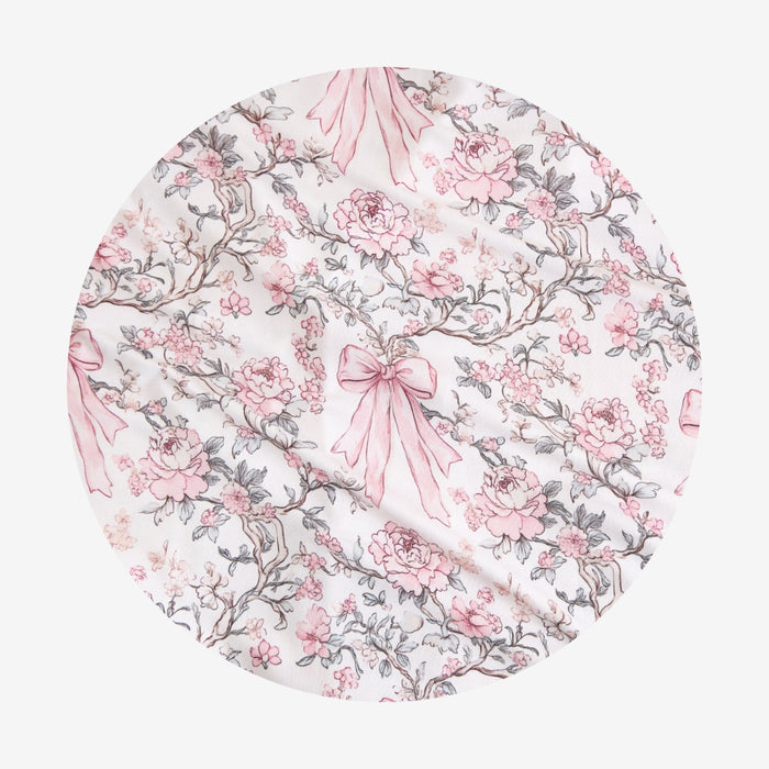 Floral patterned fabric with pink bows on a white background
