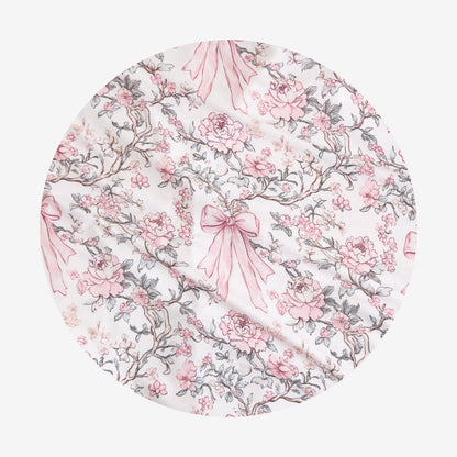 Floral patterned fabric with pink bows on a white background