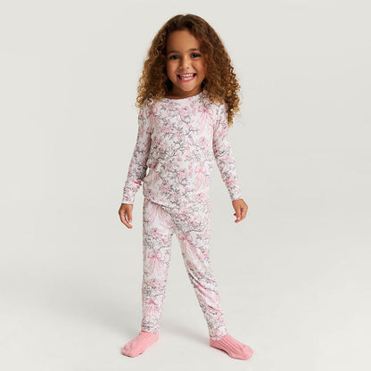Child wearing a pink floral pajama set on a white background