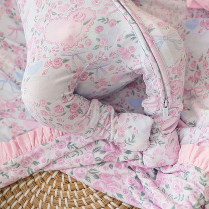 Footie detail of floral-patterned baby one piece with pink and white colors.