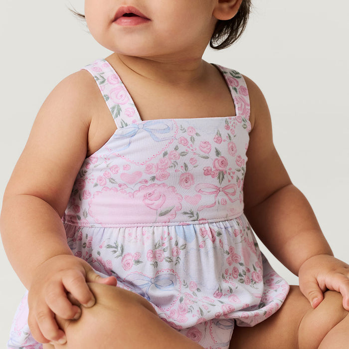 Baby wearing a floral romper with a white background
