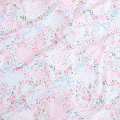 Floral pattern with pink flowers and blue ribbons on a light background