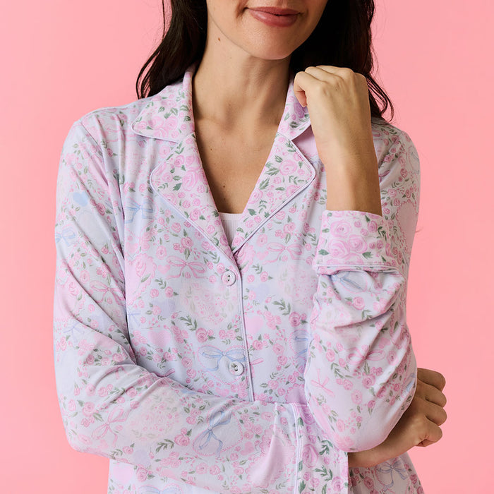 Woman wearing a pink floral pajama top against a pink background
