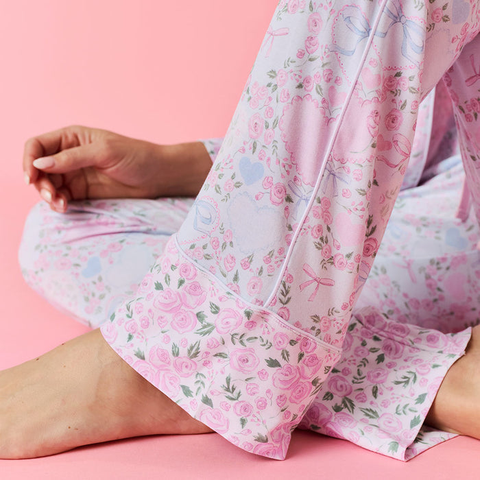 Close up detail of Person wearing a pink floral pajama pant on a pink background