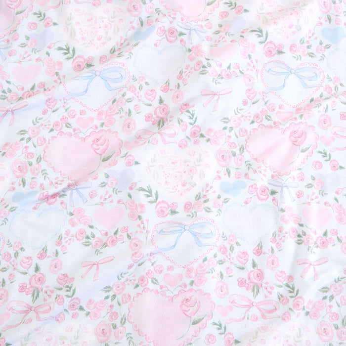 Floral pattern with pink flowers and blue ribbons on a white background