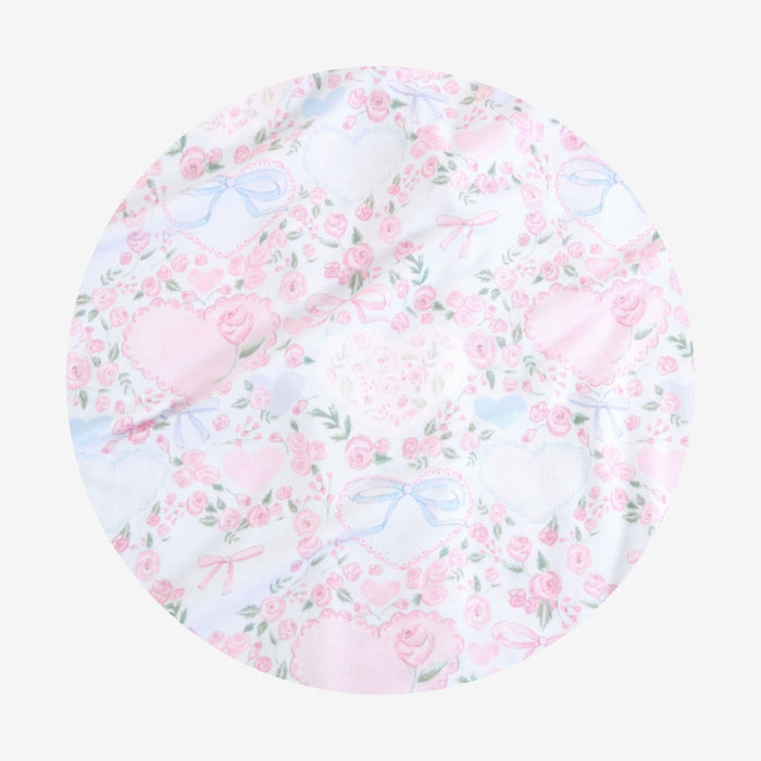 Round pink floral cushion with blue birds on a white background