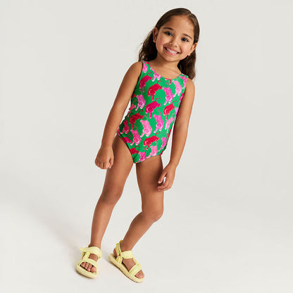 Young girl wearing a colorful swimsuit with pink and green patterns on a white background