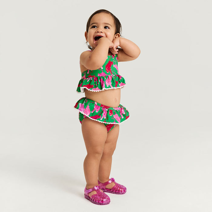 Child wearing a colorful two-piece swimsuit on a white background