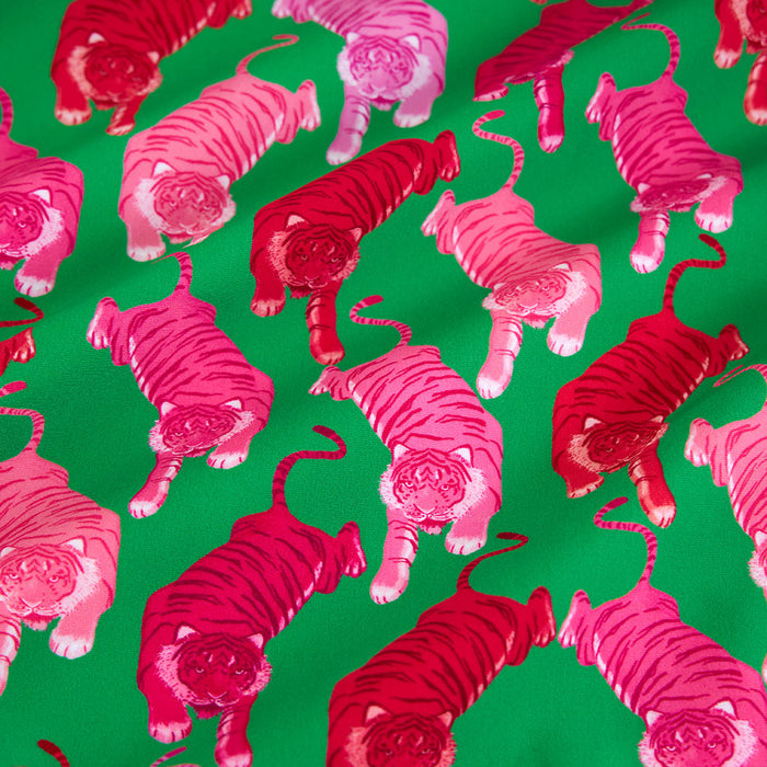 Pattern of pink tigers on a green background