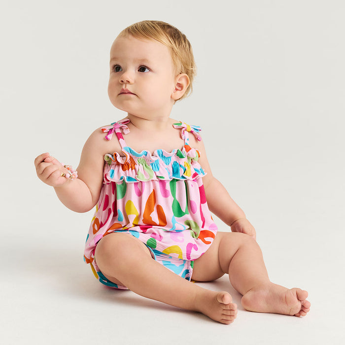 Baby wearing a colorful leopard print set on a white background