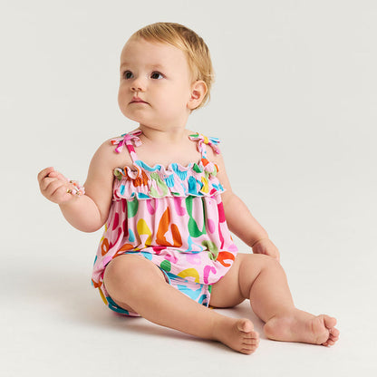 Baby wearing a colorful leopard print set on a white background