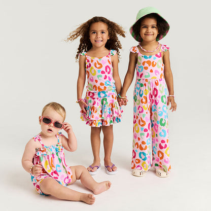Three children wearing colorful animal print outfits on a white background