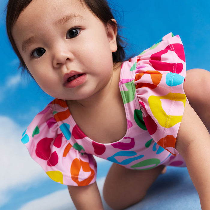 Child wearing a colorful swimsuit against a blue sky background
