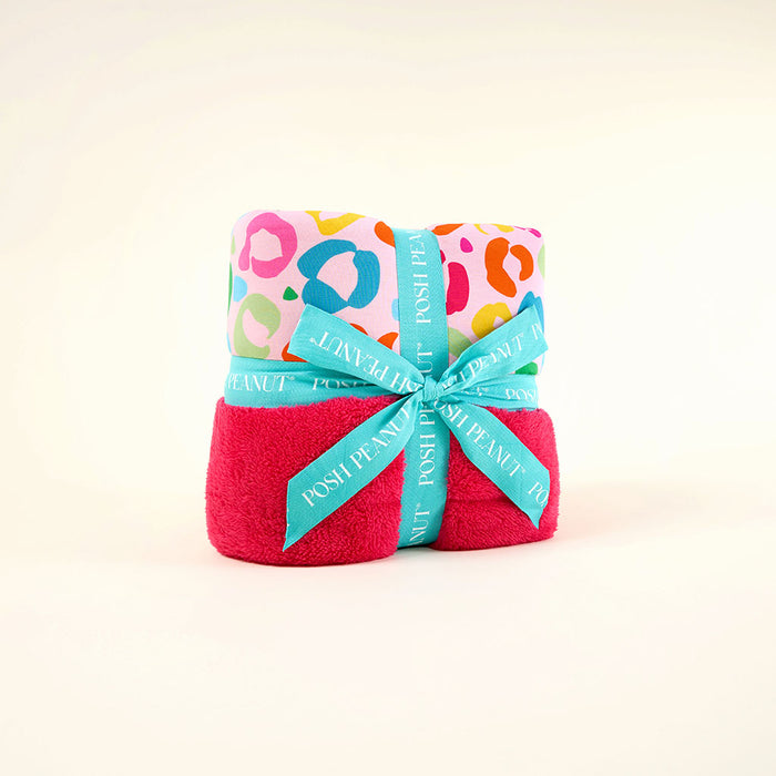 Folded towel with colorful pattern and turquoise ribbon on a white background