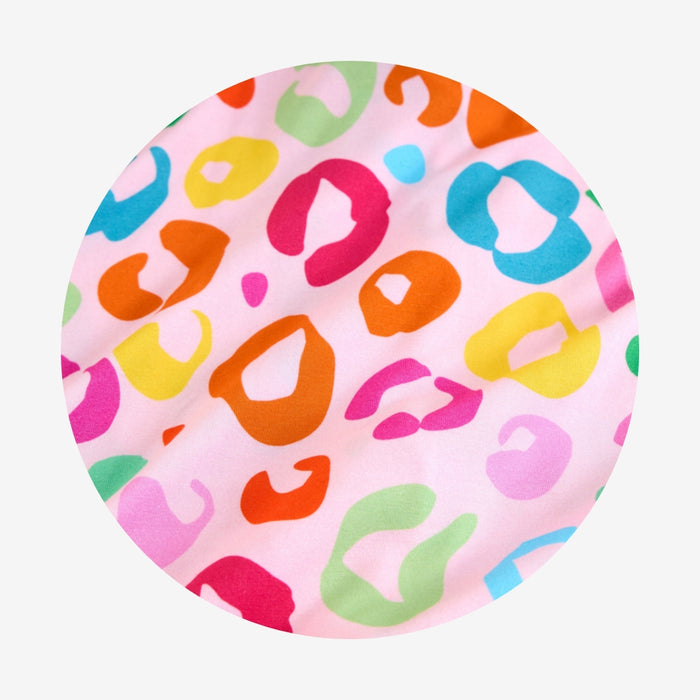Round pink fabric with colorful leopard print pattern on a white background