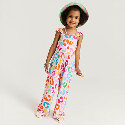 Child wearing a colorful leopard print jumpsuit and hat on a white background