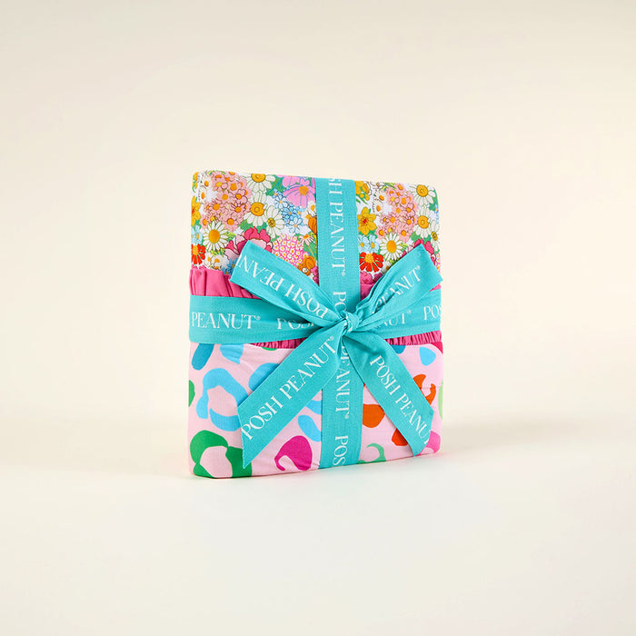 wrapped blanket with a patterned ribbon on a light beige background
