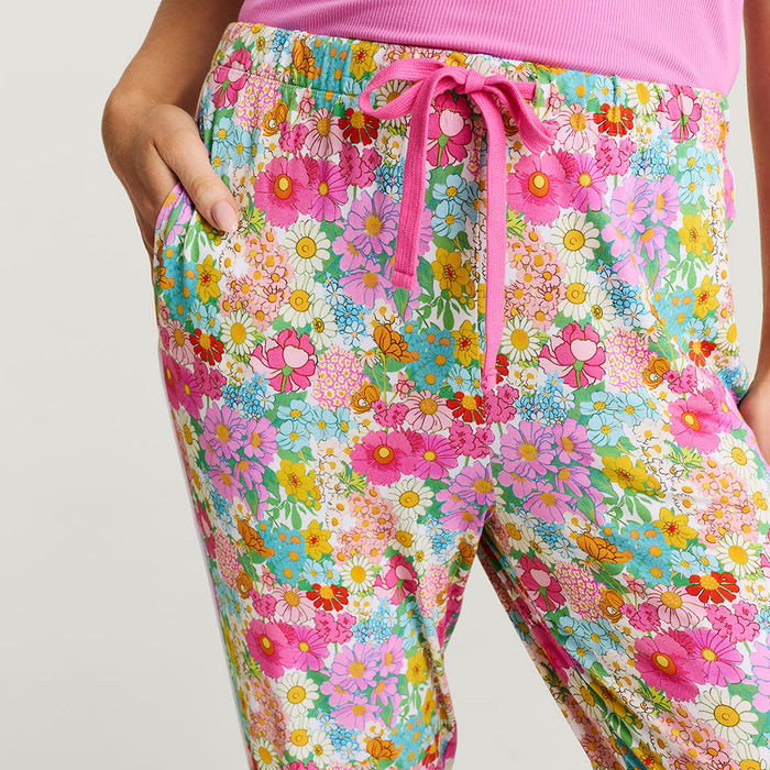 Colorful floral pajama pants with a pink drawstring on a light gray background