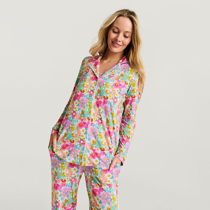 Woman wearing a colorful floral pajama set on a plain background