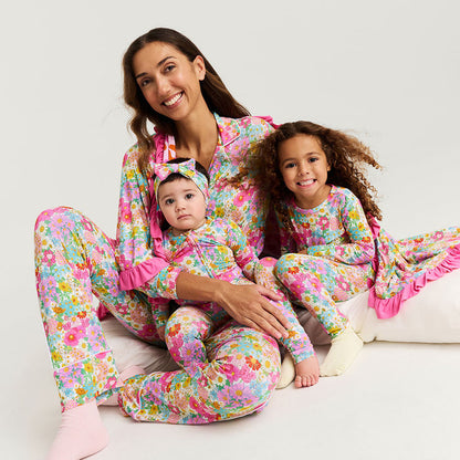 Woman and two children wearing matching floral pajamas on a white background