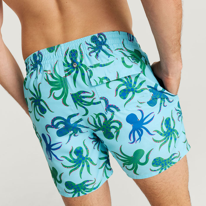Blue swim shorts with octopus pattern on a neutral background