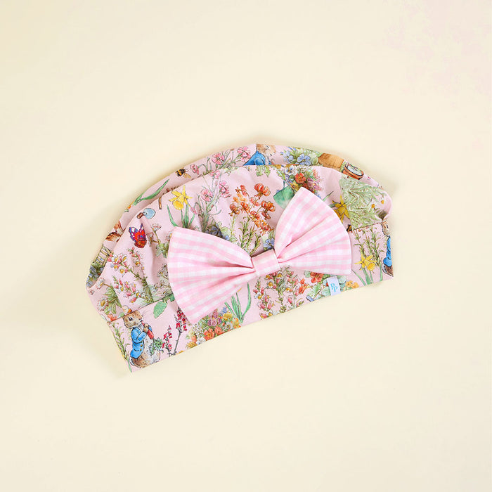 Floral chef's hat with a large pink bow on a beige background