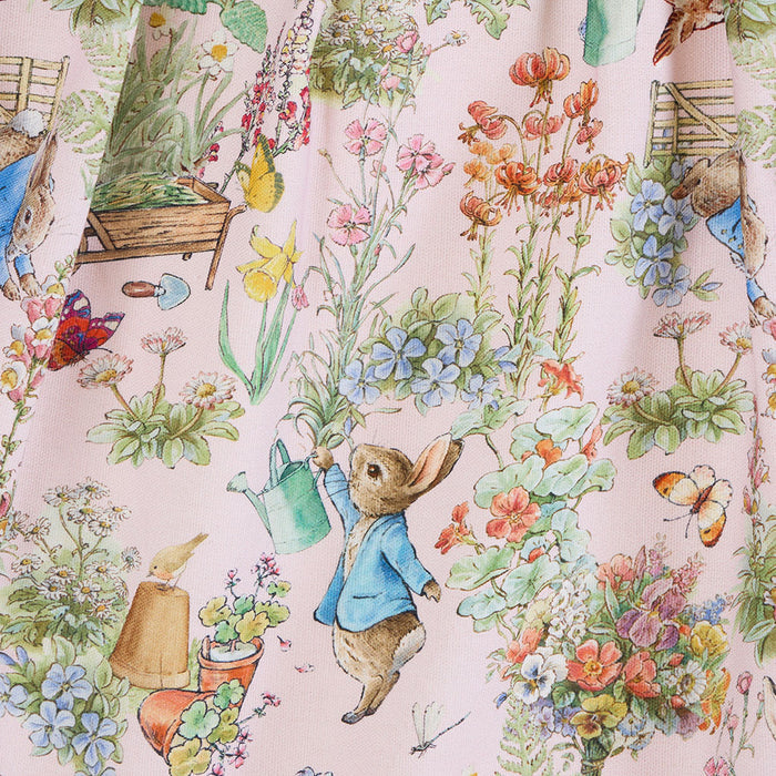 Illustration of a garden scene with flowers, a watering can, and a character in a blue coat.