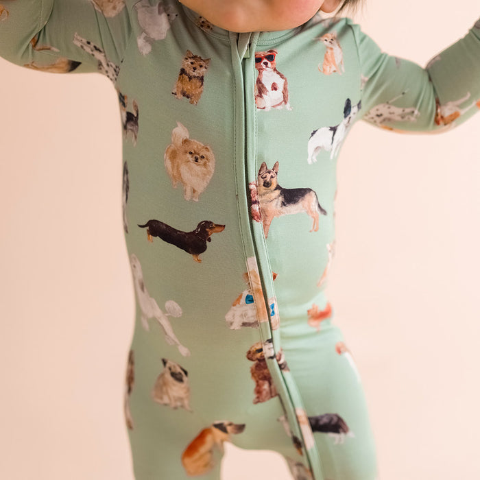 close-up of child wearing a green one piece with dog pattern print.