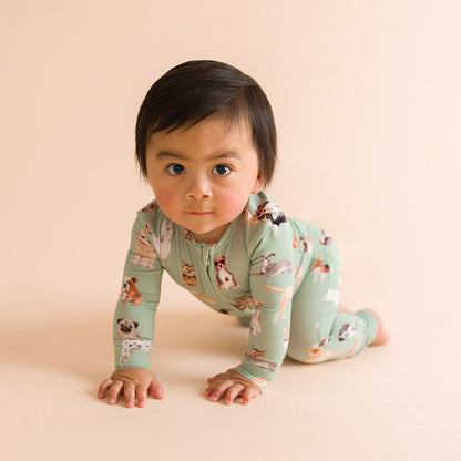 Child crawling wearing a green dog printed one piece.