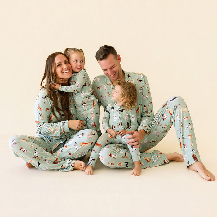 Family of four wearing matching pajamas with a forest animal pattern on a beige background