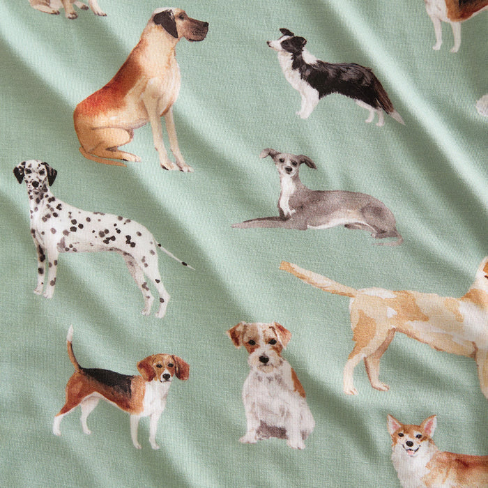 Fabric with illustrations of various dogs on a green background