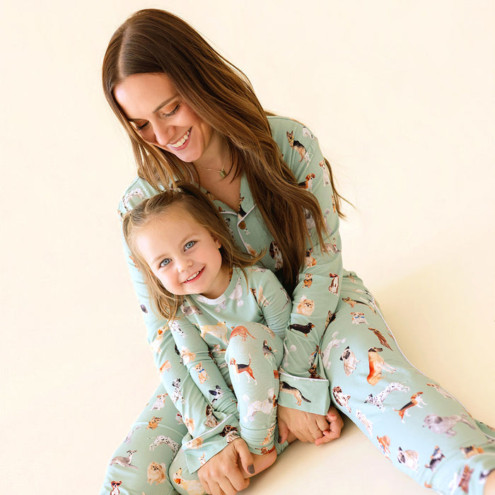 Woman and child wearing matching pajamas with a dog pattern on a light background