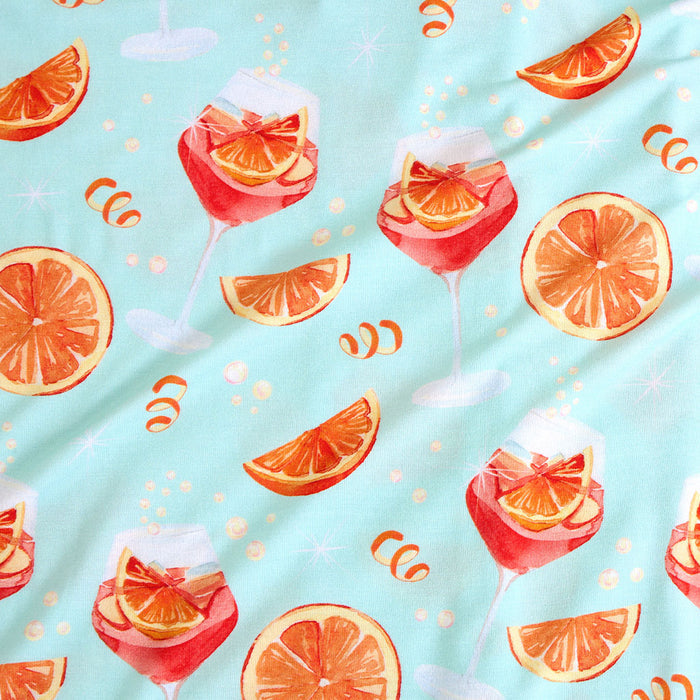Pattern of cocktails with orange slices on a light blue background