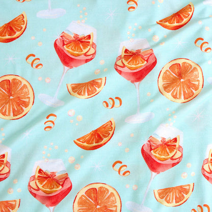 Pattern of cocktails with orange slices on a light blue background